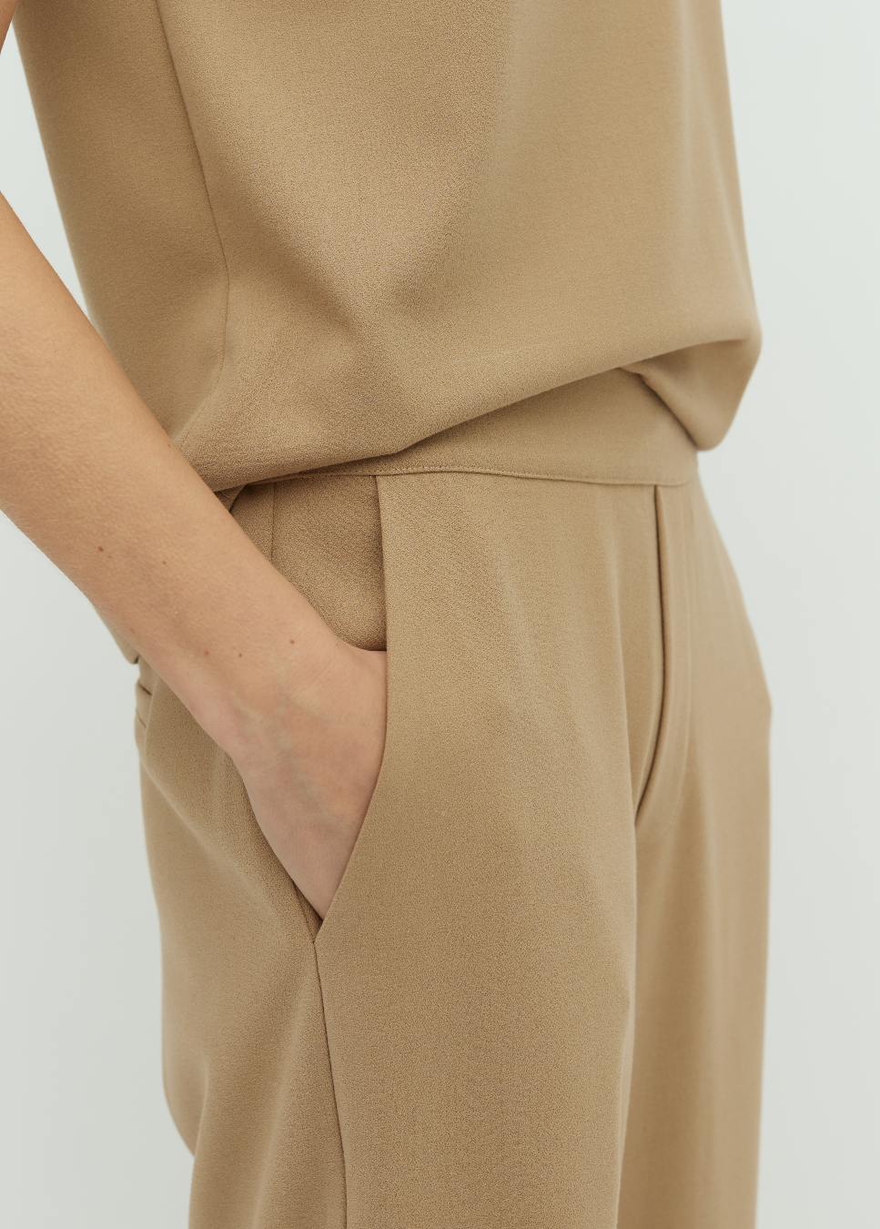 Beige geweven broek van het merk mbyM. De beige pantalon Emmett heeft een elastische tailleband achter, steekzakken en fake achterzakken. De beige pantalon heeft een wide leg fit. Combineer de beige broek met de bijpassende beige top Gianne van mbyM. Shop de  nieuwe collectie dames bij bij dameskleding Boetiek Aniek.