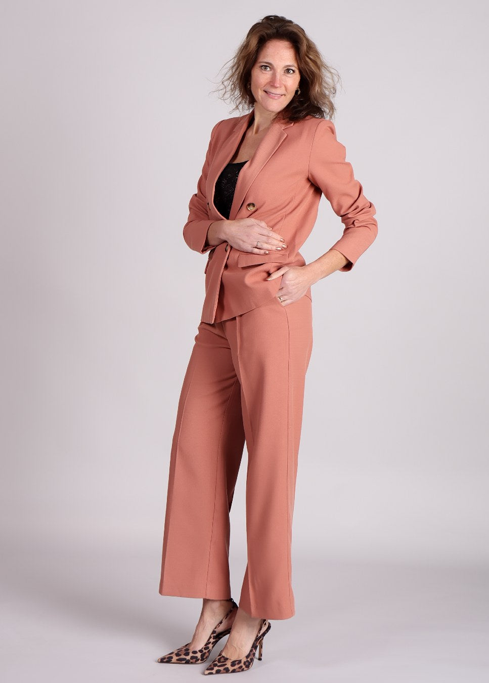 Zijaanzicht van de terracotta broek grace en mila pierre pants gecombineerd met bijpassend blazer