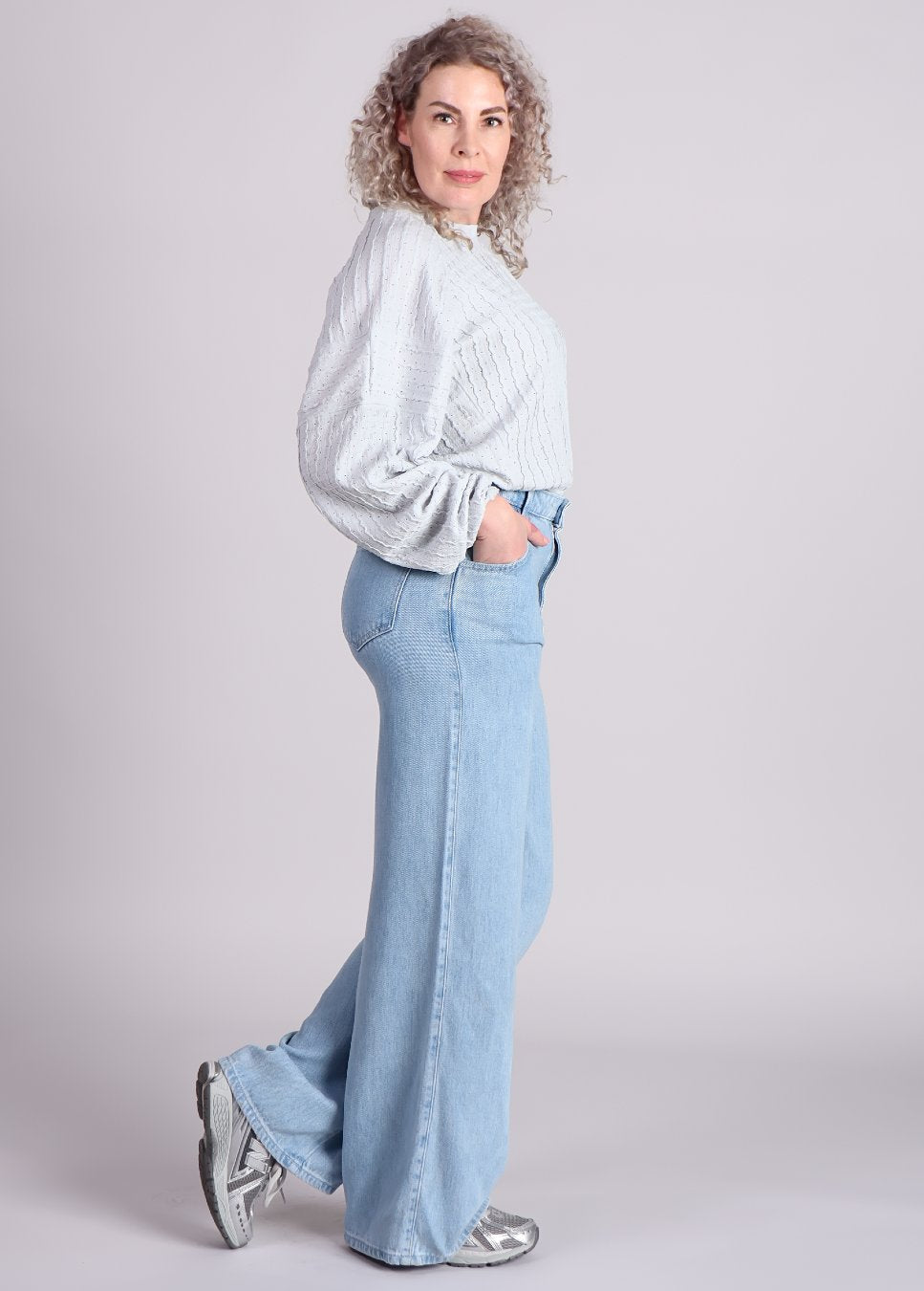 zijaanzicht van de Homage flowy palazzo jeans lichtblauw van kleur met lichtblauwe Amaya blouse