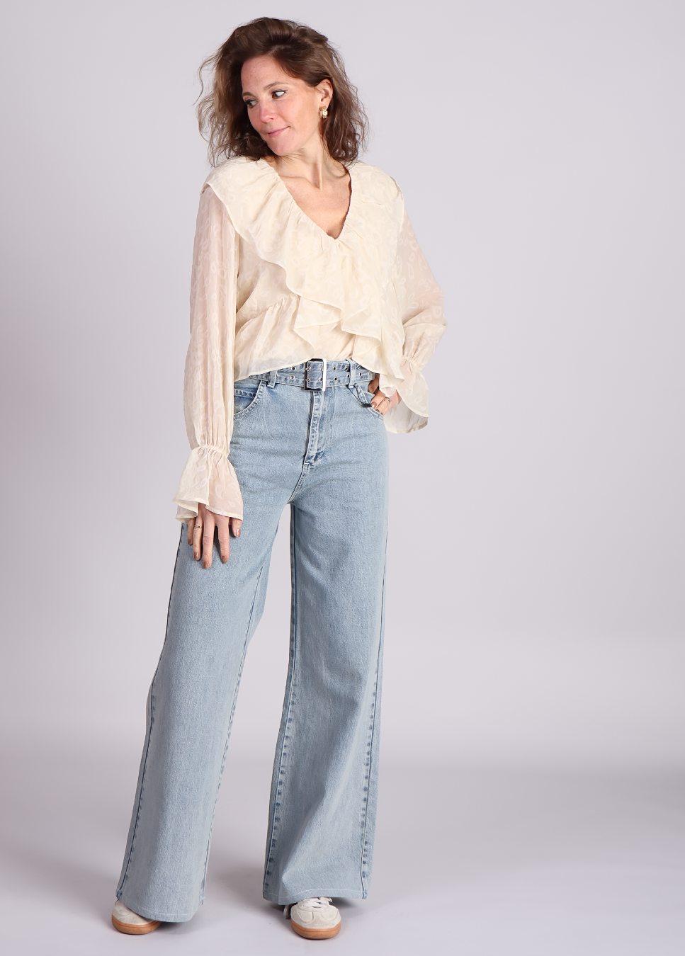 Beige quinn blouse met ruffles van studio Amaya op model met jeans